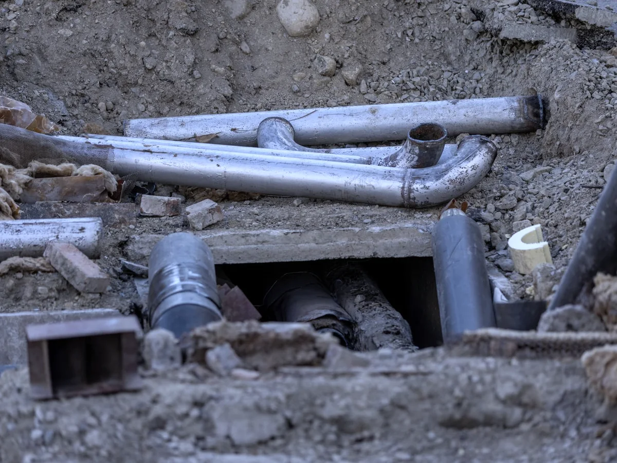 Drain and sewer lines exposed in an open trench during a repair
